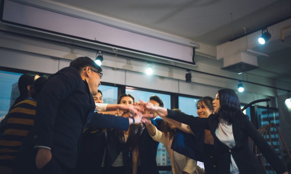 Large business team showing unity with their hands together